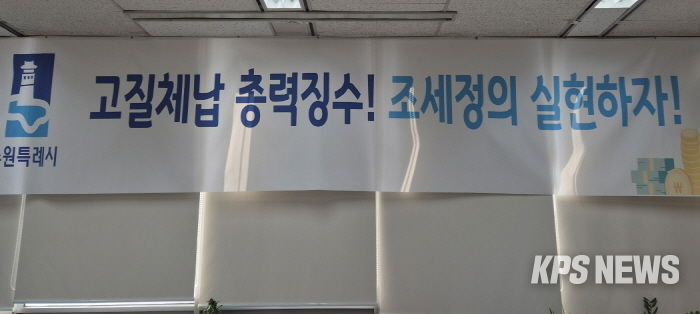 ‘고질체납 총력 징수! 조세정의 실현하자!’ 수원시 징수과 사무실에 걸려 있는 현수막.