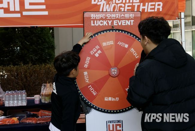 화성시민이 화성FC 게릴라 팝업 부스에서 경품 룰렛 이벤트에 참여하고 있다